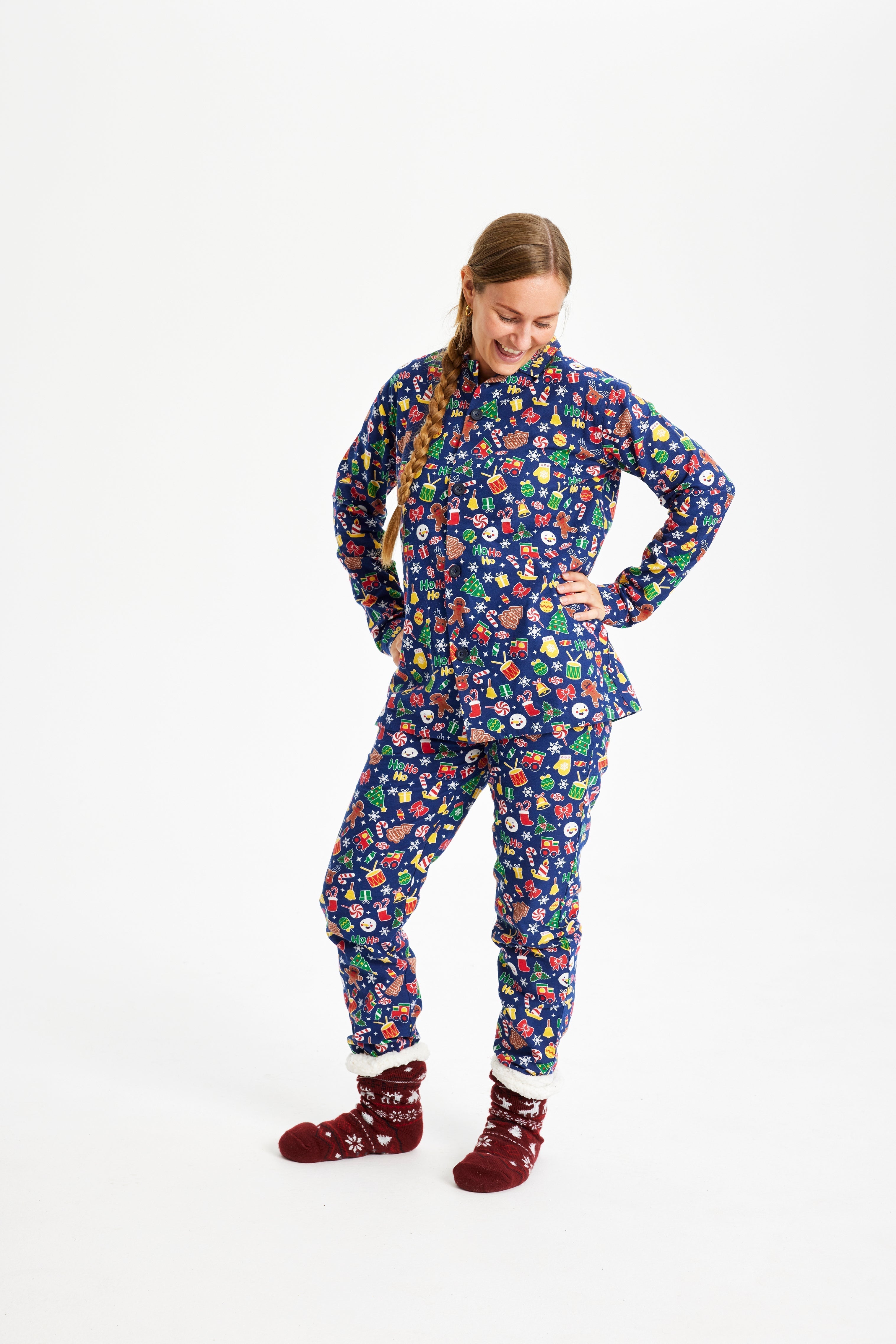 Een poserende vrouw in een blauwe kerstpyjama.